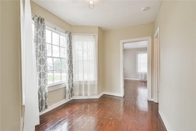 unfurnished room featuring a healthy amount of sunlight and dark hardwood / wood-style floors