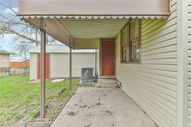 doorway to property featuring a yard and central AC unit