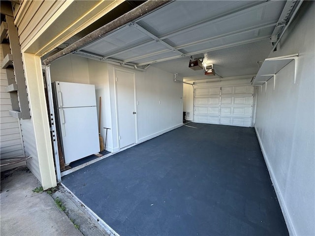 garage with a garage door opener and freestanding refrigerator