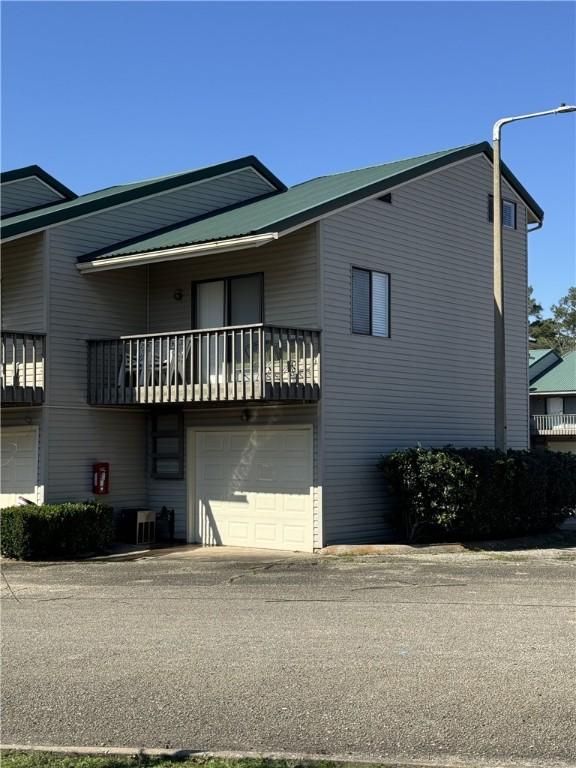 exterior space featuring a garage and a balcony