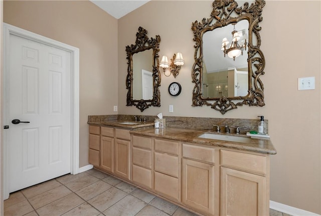 full bath with double vanity, tile patterned flooring, baseboards, and a sink