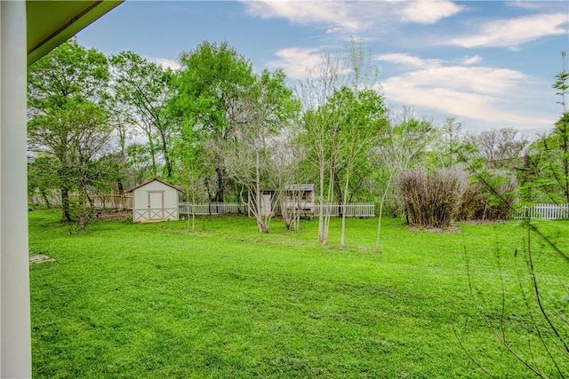 view of yard featuring a storage shed, an outdoor structure, and a fenced backyard