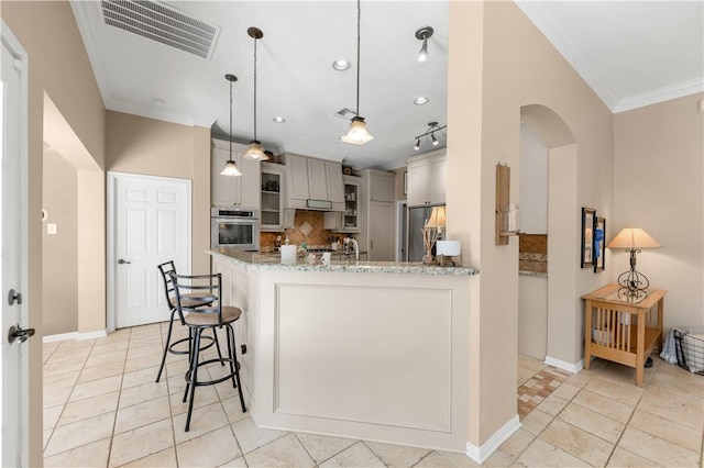 kitchen with visible vents, backsplash, appliances with stainless steel finishes, ornamental molding, and a peninsula