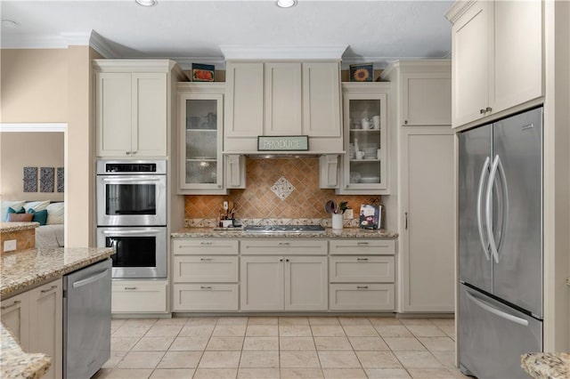 kitchen featuring stainless steel appliances, ornamental molding, light stone counters, and tasteful backsplash