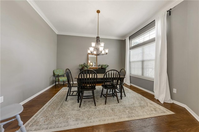 dining area with dark wood-style floors, ornamental molding, a chandelier, and baseboards