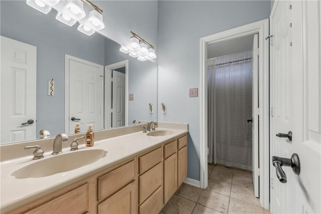 full bath featuring double vanity, tile patterned flooring, and a sink