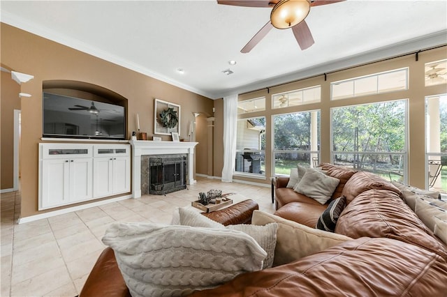 living area featuring light tile patterned floors, ceiling fan, a fireplace, and crown molding