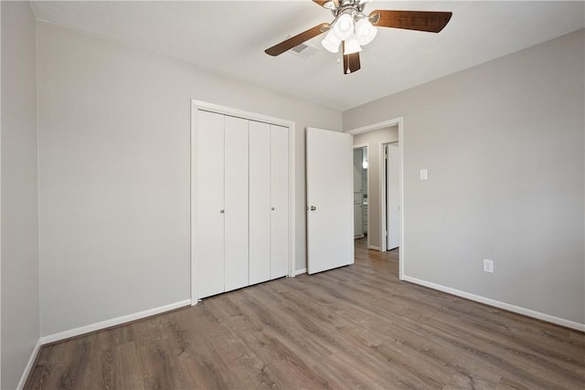 unfurnished bedroom featuring hardwood / wood-style floors, ceiling fan, and a closet