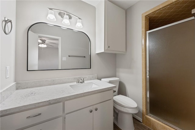 bathroom with vanity, toilet, and a shower with door