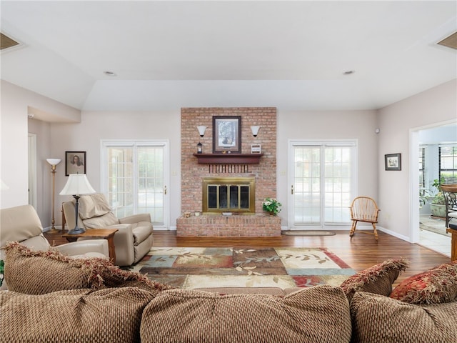 living room featuring a fireplace, vaulted ceiling, and hardwood / wood-style flooring