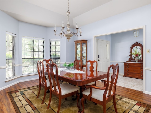 dining room featuring light wood-type flooring and an inviting chandelier