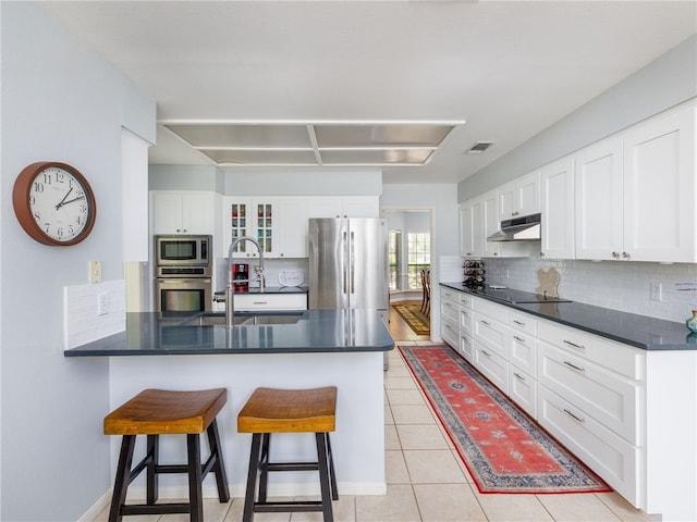 kitchen featuring white cabinetry, sink, a kitchen breakfast bar, kitchen peninsula, and appliances with stainless steel finishes