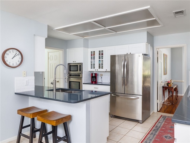 kitchen with sink, light tile patterned floors, white cabinetry, kitchen peninsula, and stainless steel appliances