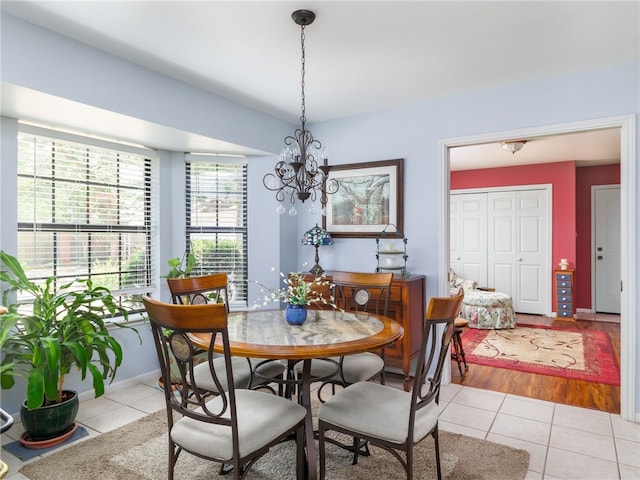 dining area featuring light tile patterned floors and an inviting chandelier