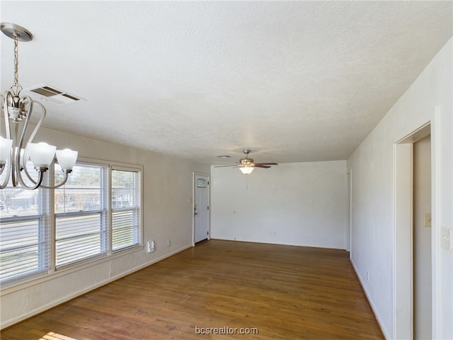 interior space with ceiling fan with notable chandelier, a textured ceiling, and dark hardwood / wood-style floors