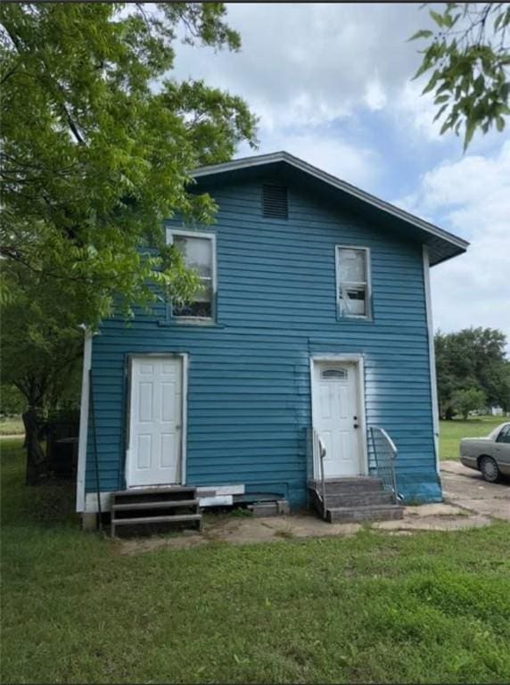 back of property featuring a yard and entry steps