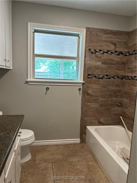 full bathroom with tile patterned floors, vanity, tiled shower / bath combo, and toilet