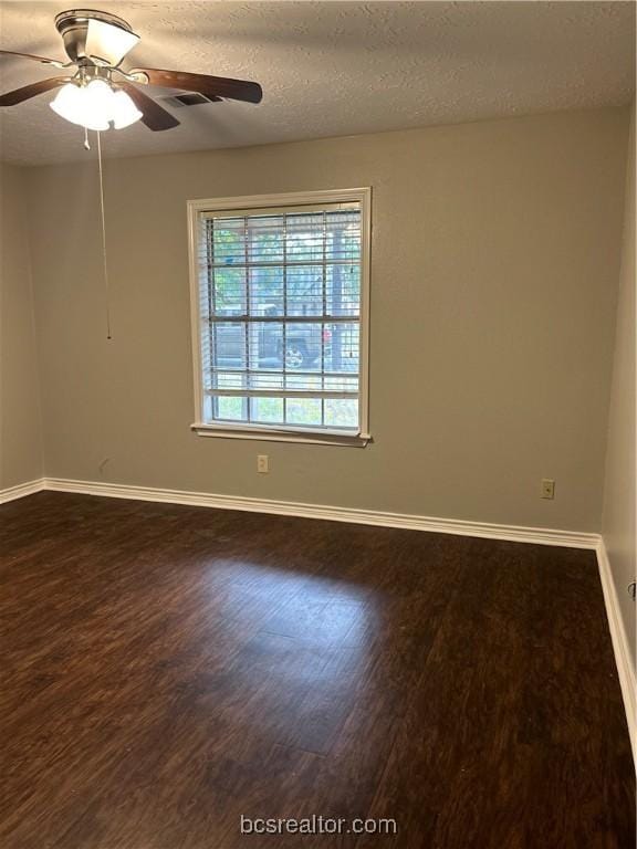 empty room featuring a textured ceiling, dark hardwood / wood-style floors, and ceiling fan