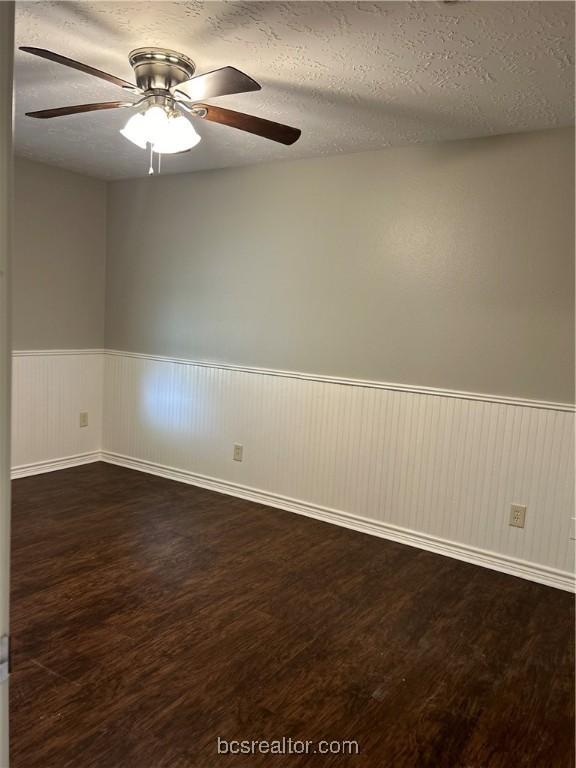 unfurnished room featuring a textured ceiling and dark hardwood / wood-style flooring