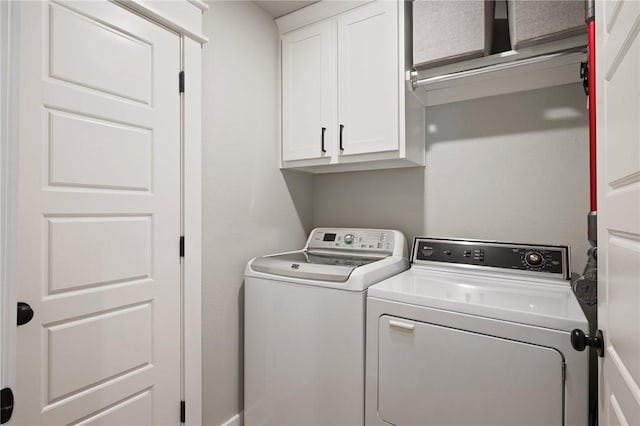 washroom featuring cabinets and washer and clothes dryer