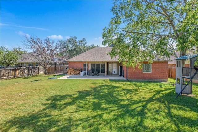 back of house featuring a patio area and a yard