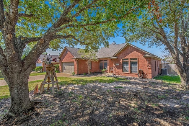 ranch-style home featuring a front yard, a garage, and central air condition unit