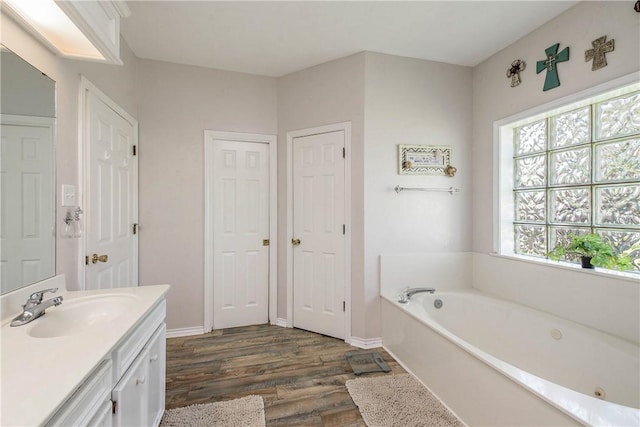 bathroom featuring hardwood / wood-style floors, vanity, and a tub to relax in