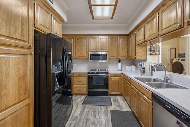 kitchen with black appliances, crown molding, light wood-type flooring, and sink