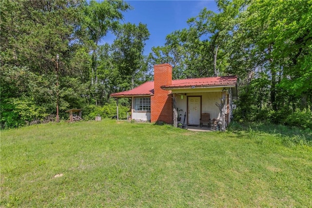 180 Fcr 797, Donie, TX 75838 - back of house featuring a chimney, a lawn, and metal roof
