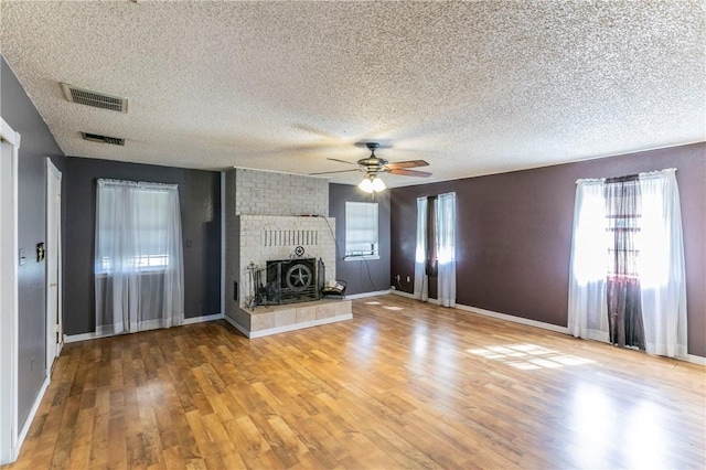 180 Fcr 797, Donie, TX 75838 - unfurnished living room featuring a textured ceiling, light wood finished floors, ceiling fan, baseboards, and a fireplace