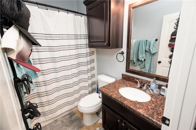 bathroom with toilet, vanity, and tile patterned floors