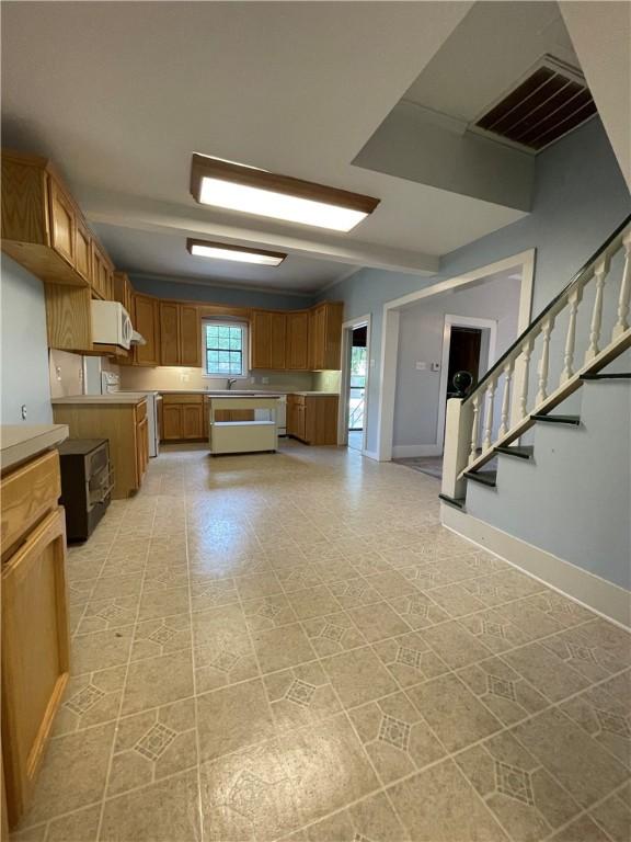 6268 Fm 2269, Cameron, TX 76518 - kitchen with brown cabinetry, baseboards, light countertops, and a sink