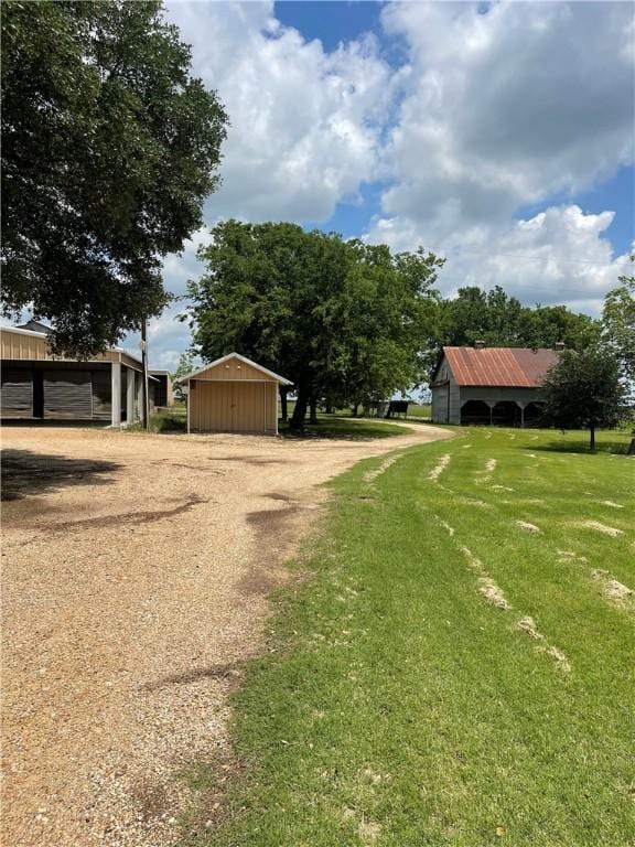 6268 Fm 2269, Cameron, TX 76518 - view of green lawn with dirt driveway, an outbuilding, and a pole building