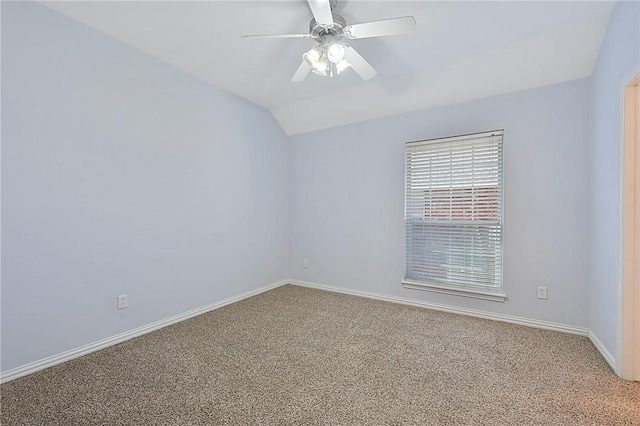 empty room featuring ceiling fan, vaulted ceiling, and carpet flooring