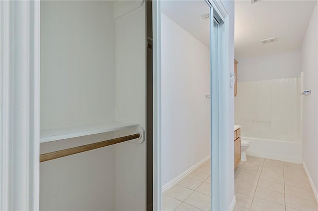 bathroom with toilet, vanity, and tile patterned floors