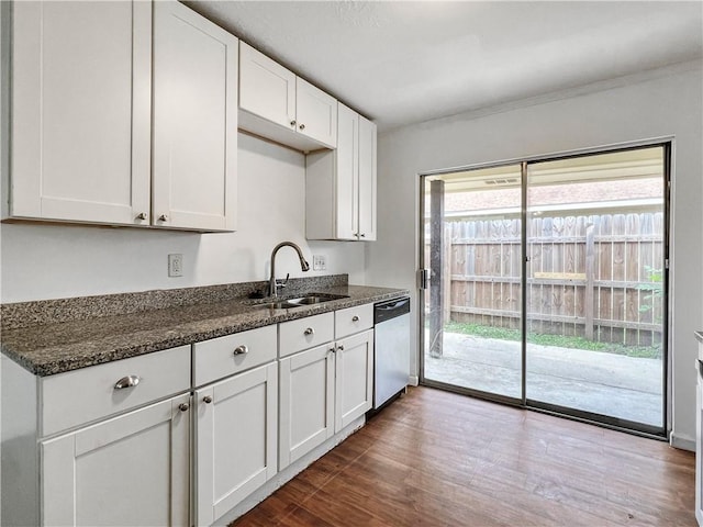 kitchen featuring white cabinetry, stainless steel dishwasher, dark stone counters, and sink