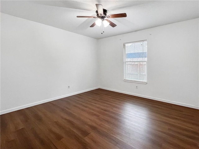 empty room with dark hardwood / wood-style floors and ceiling fan