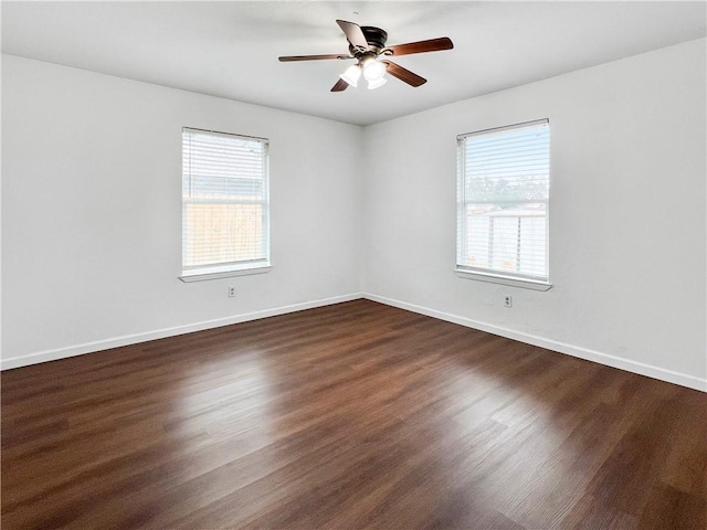 spare room with dark hardwood / wood-style flooring, ceiling fan, and a healthy amount of sunlight