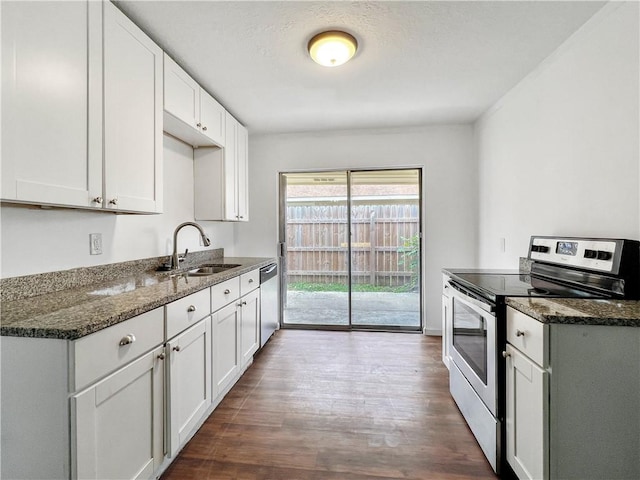 kitchen with dark stone countertops, white cabinetry, and stainless steel appliances