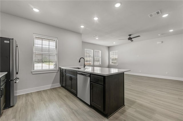 kitchen with appliances with stainless steel finishes, light hardwood / wood-style floors, sink, and plenty of natural light