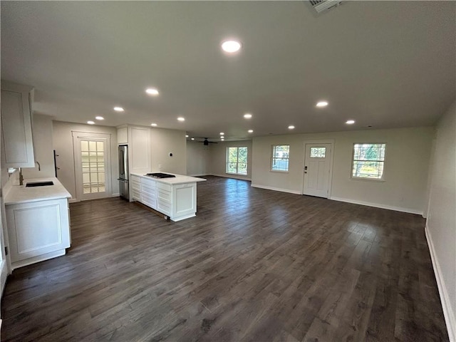 kitchen featuring stainless steel fridge, white cabinets, dark hardwood / wood-style floors, and gas cooktop