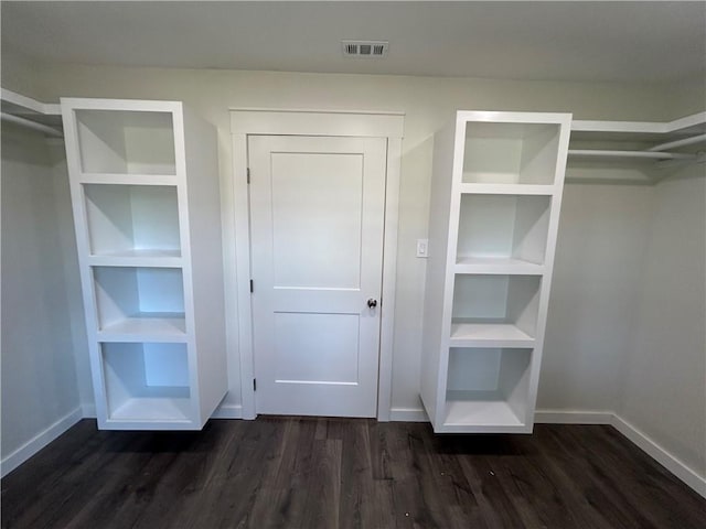 walk in closet with dark hardwood / wood-style flooring