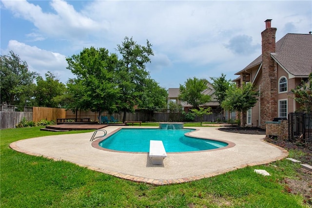 view of pool with a patio area, a diving board, and a yard