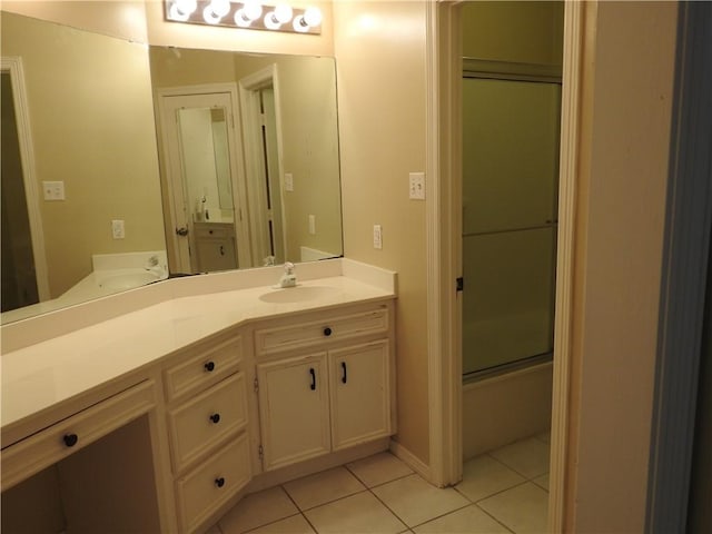 bathroom featuring tile patterned flooring, vanity, and combined bath / shower with glass door