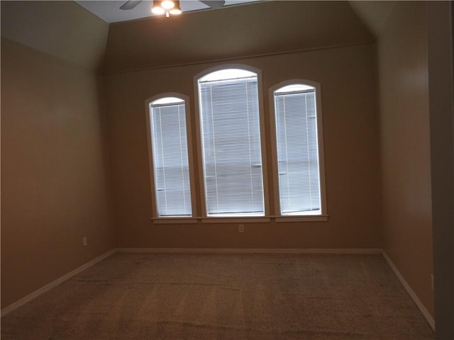 carpeted empty room featuring ceiling fan and vaulted ceiling