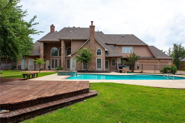 view of swimming pool featuring an in ground hot tub, a yard, a deck, and a patio area