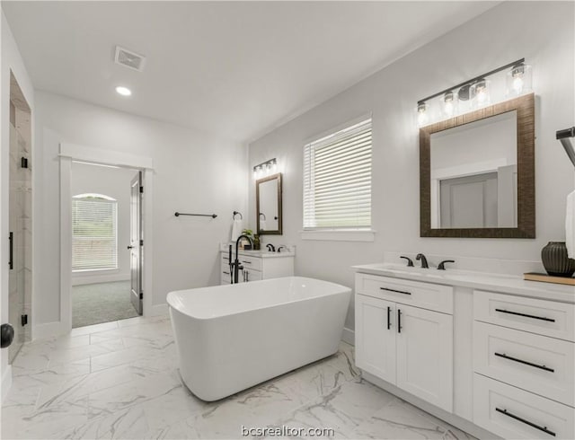2023 Lola Ln, Bryan, TX 77807 - full bath featuring marble finish floors, a soaking tub, two vanities, a shower stall, and recessed lighting