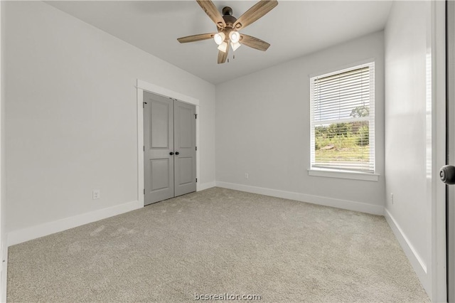 empty room with ceiling fan and light colored carpet