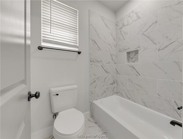 bathroom with tiled shower / bath combo and toilet