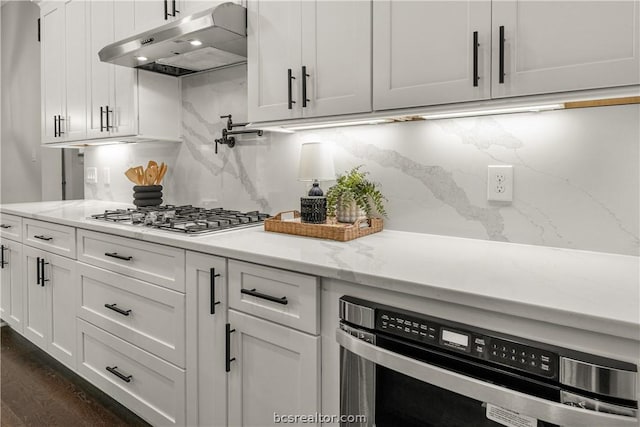 kitchen featuring light stone countertops, white cabinetry, stainless steel gas cooktop, and tasteful backsplash